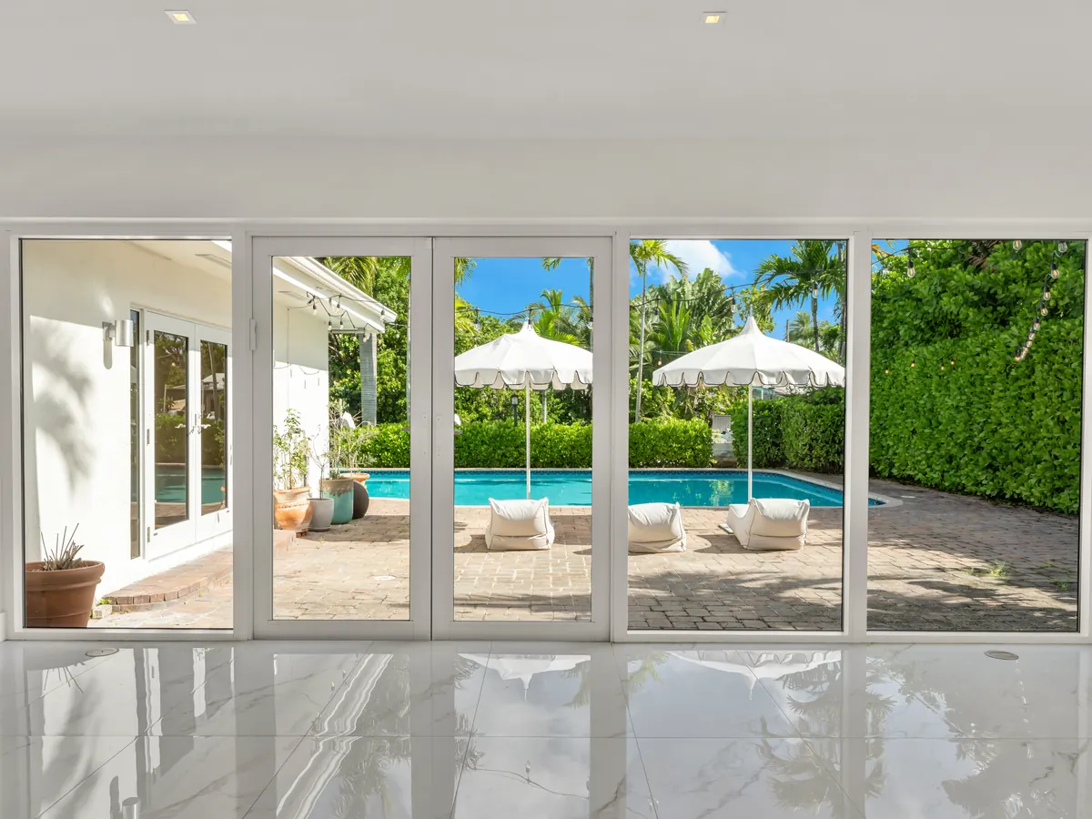 Bright living space opening through glass doors to the pool
