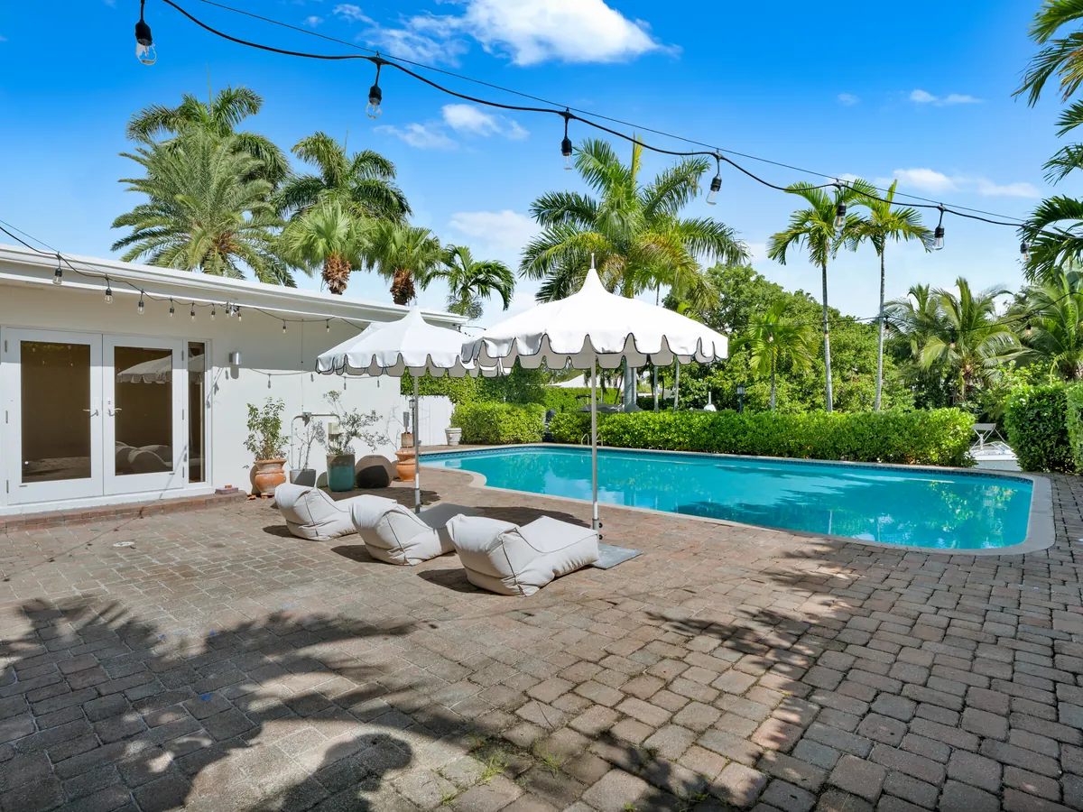 Oversized private pool surrounded by palms and a spacious patio